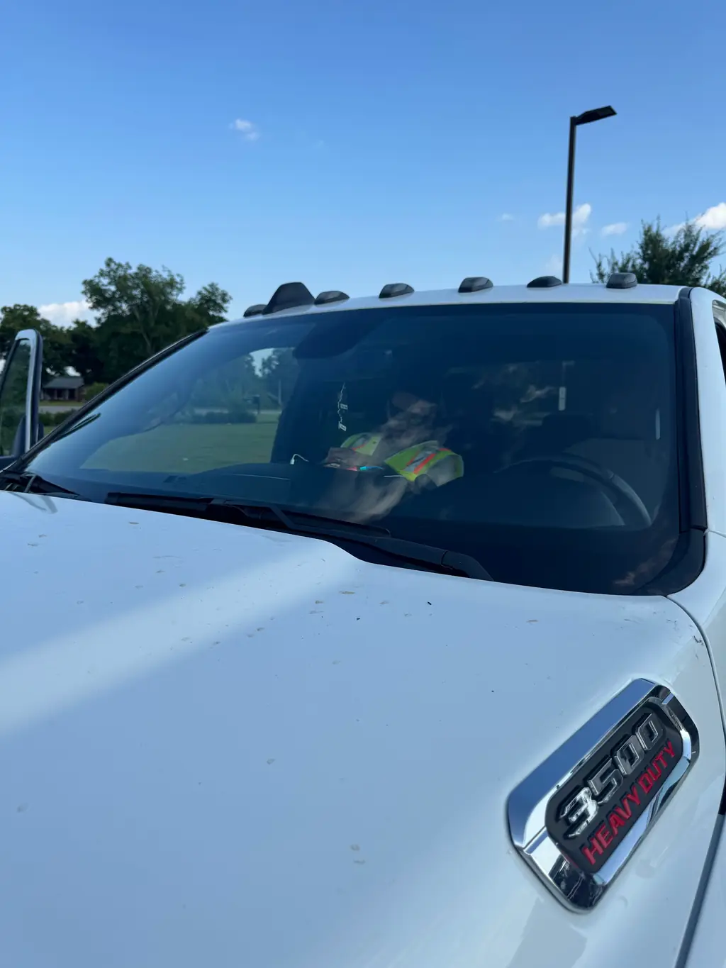A technician visible through the freshly fitted windshield of a Ram 3500