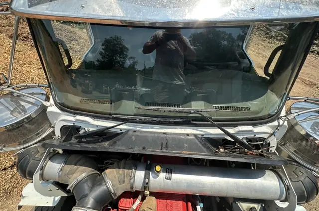 A Class 8 tractor unit with its hood tilted forward and a new windshield fitted